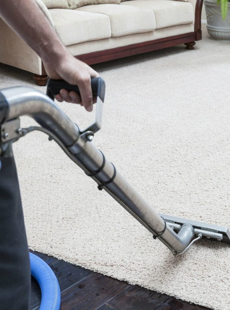 Man cleaning carpets in home